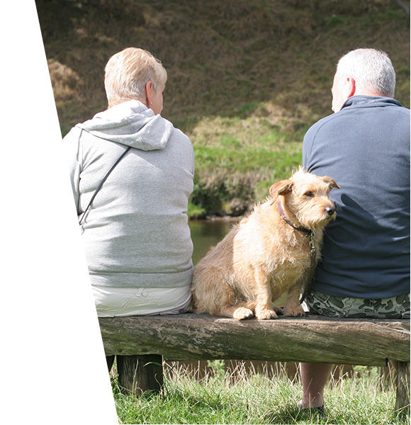 Couple enjoying a quiet moment by the river with their dog